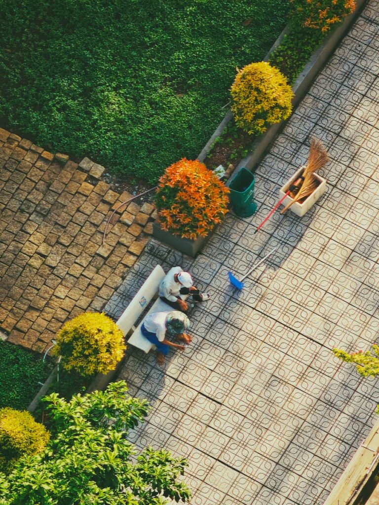 Top-down shot of garden workers maintaining greenery in Ho Chi Minh City, Vietnam park.